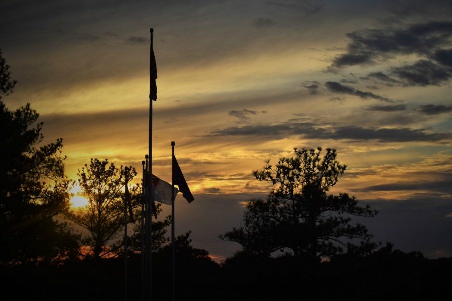 Photo by Christian Hammer. Sunset behind the American flag.