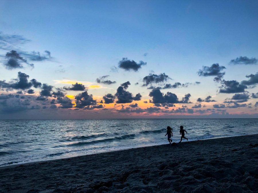 A spectacular sunset while little children chase each other through the waves. 