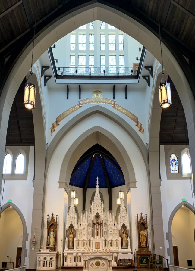 The restored antique high altar is seen in this photo of Christendom Colleges Christ the King Chapel. The Sanctus, Sanctus, Sanctus, written by the late Mandy Hain, is also seen above the altar.